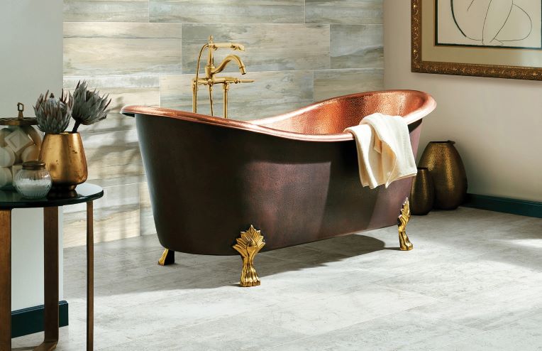 large neutral grey floor tiles in a stylish bathroom with a stand alone copper tub